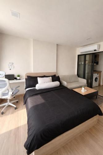 a bedroom with a large bed and a living room at Modern Apartment with Gym & Pool in Kathu