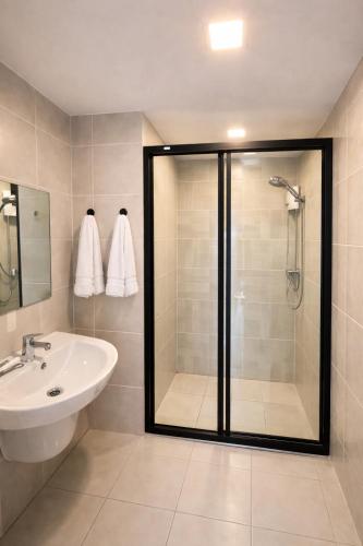 a bathroom with a shower and a sink at Modern Apartment with Gym & Pool in Kathu