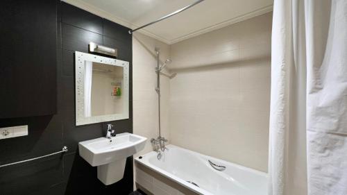 a bathroom with a sink and a tub and a mirror at 2-bedroom apartment with terrace VistaRoja in Granadilla de Abona