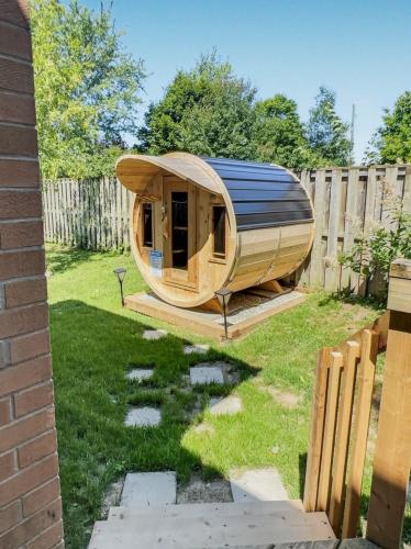 a wooden sauna in a backyard with a fence at Walkerton Sauna Suite in Walkerton