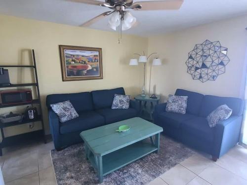 a living room with a blue couch and a table at Super Cute With Deeded Beach Access (#26) - Sleeps 5 in Gulf Shores