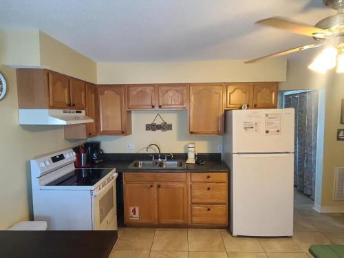 a kitchen with a white refrigerator and wooden cabinets at Super Cute With Deeded Beach Access (#26) - Sleeps 5 in Gulf Shores