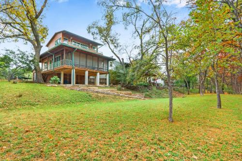 a large house on a hill with trees in front of it at Cypress Star in Wimberley