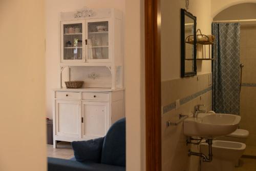 a bathroom with a sink and a white cabinet at Padulella Mare - HelloElba in Portoferraio