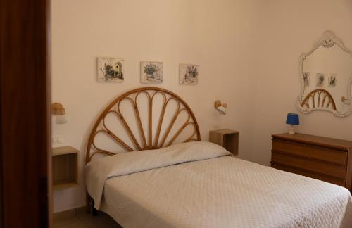 a bedroom with a bed and a mirror on the wall at Padulella Mare - HelloElba in Portoferraio