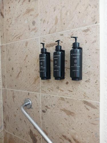 three black bottles on a wall in a bathroom at Hacienda Panoaya in Amecameca de Juárez