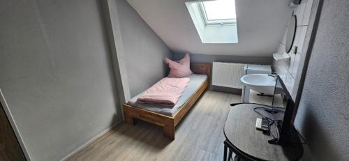 a small room with a bed and a sink at Pension Raunheim in Raunheim