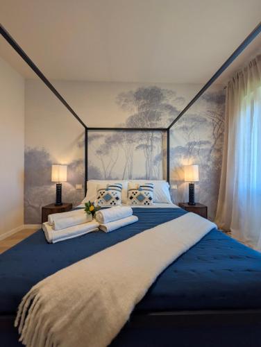 a bedroom with a large blue bed with two lamps at La Sosta del Cardinale in Montefiascone