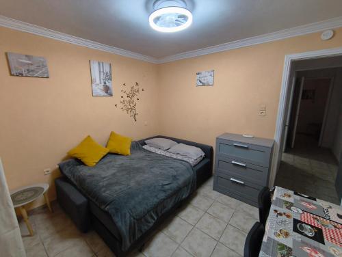 una piccola camera da letto con un letto con cuscini gialli di Kipsely room ad Atene