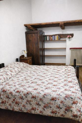 a bedroom with a bed with a floral bedspread at Appartamento Alta Valle Maira - Midia in Villaro