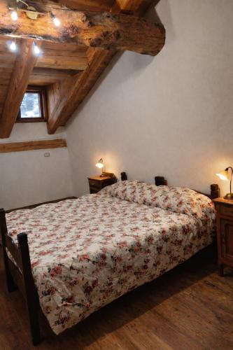 a bedroom with a bed with a floral bedspread at Appartamento Alta Valle Maira - Midia in Villaro