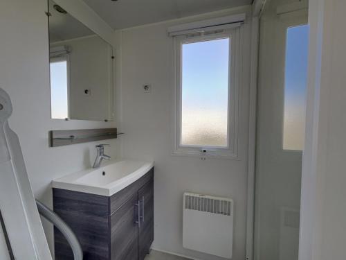 a bathroom with a sink and a window at Mobilhome L'Instant Vacances - La Plage in Mimizan-Plage
