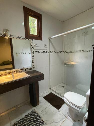 a bathroom with a shower and a toilet and a sink at Sítio Funilândia - MG in Funilândia