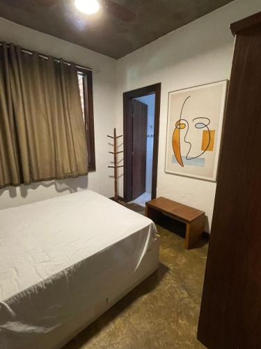 a bedroom with a white bed and a window at Sítio Funilândia - MG in Funilândia