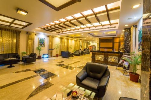 un vestíbulo con sofás y sillas en un edificio en Amantra Comfort Hotel, en Udaipur
