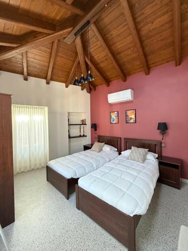 a bedroom with two beds and a pink wall at La Corte dei Mercanti by Stresahome - Centro Storico in Stresa