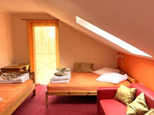 a room with two beds and a couch and a window at Beachside Guest House Strautini in Plieņciems