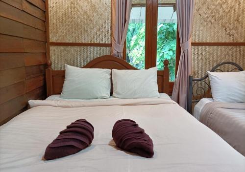 a bed with a pair of towels on it at LUCKY PAI Resort&Hostel in Pai