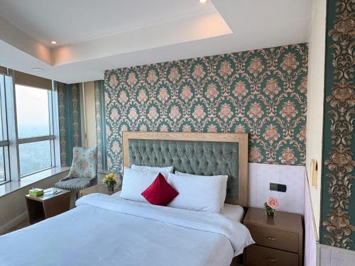 a bedroom with a large white bed with red pillows at MZK Apartment in Islamabad