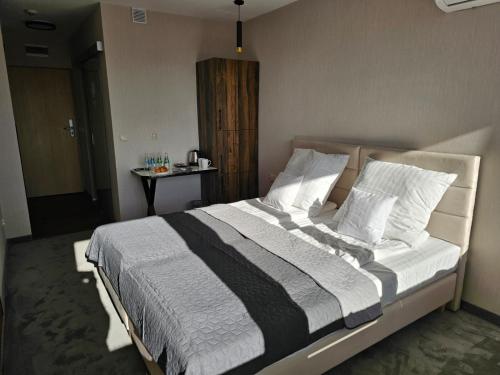 a bedroom with a large bed with white pillows at Ośrodek Uzdrowiskowy Biawena in Wysowa-Zdrój