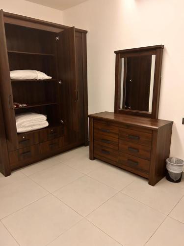 a bathroom with a wooden cabinet and a mirror at Almasar Hotel in Maţār as Sīb ad Duwalī