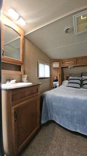 a bedroom with a bed with a sink and a mirror at Camping El Torres in Villajoyosa