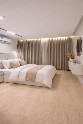 a bedroom with a large white bed and curtains at Modern Studio Near Al Haram And City Center Self Check-in in Medina