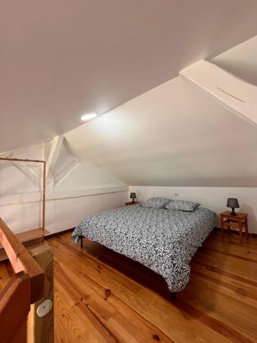 a bedroom with a bed in an attic at Gîtes de la chocolaterie in Viré