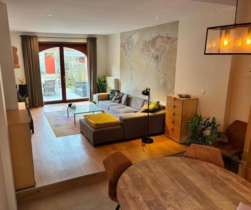 a living room with a couch and a table at Spacious Design Home with Garden near Centre in Bruges