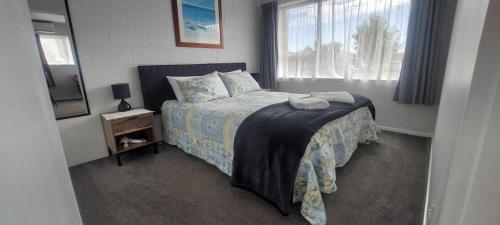 a bedroom with a bed and a window at Fantastic Two Bedroom Unit in Whakatane