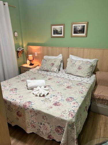 a bedroom with a bed with a pink floral bedspread at Piemonte Flat 104 B in Serra Negra