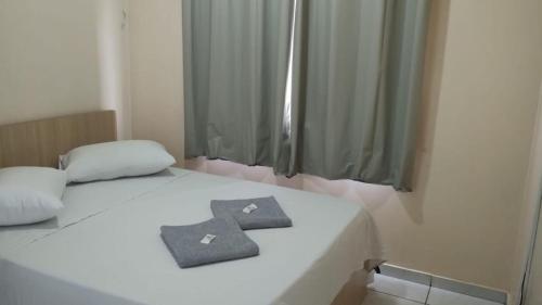 a room with two beds with a gray item on it at Golden Hotel Ltda - Próximo a DPM, Aeroporto, Rodoviaria Porto Alegre, Arena do Grêmio in Porto Alegre