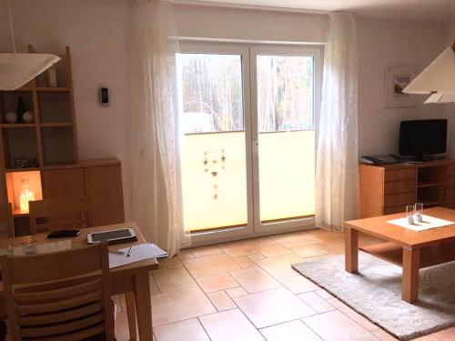 ein Wohnzimmer mit einer großen Glasschiebetür in der Unterkunft Ruhige Ferienwohnung in Graal Müritz (EW) in Graal-Müritz