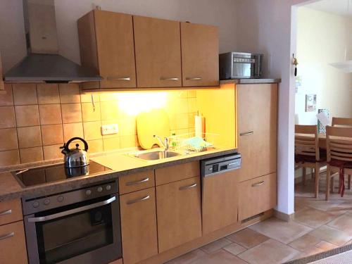 een keuken met een wastafel en een fornuis bij Ruhige Ferienwohnung in Graal Müritz (EW) in Graal-Müritz