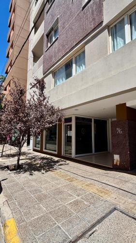 a building with a tree in front of it at Amoblado Temporal M&S 5 M in Neuquén