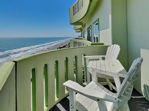 a balcony with two chairs and the ocean at Ocean Grove 902 - Pelican View in Galveston