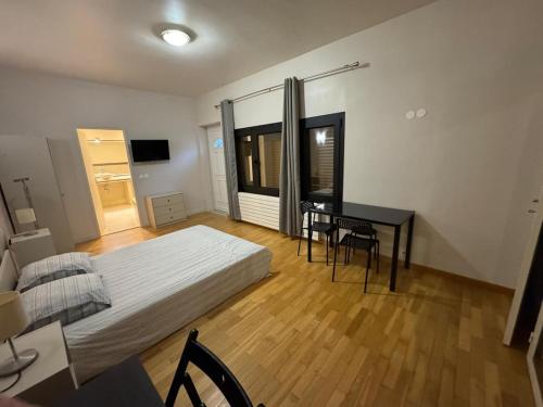 a bedroom with a bed and a desk and a table at Private Spa & Zen Atmosphere in Coubron