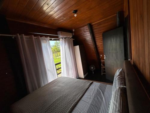 een slaapkamer met een bed en een raam bij Chalé Sossegado in Treviso