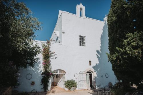 a white church with a steeple on top of it at Masseria Le Cerase in Conversano
