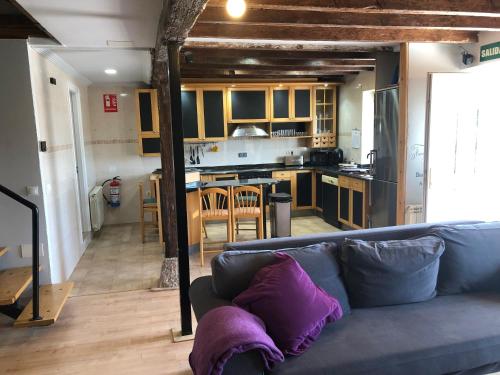 a living room with a couch and a kitchen at Alojamiento Costa Quebrada in Soto de la Marina