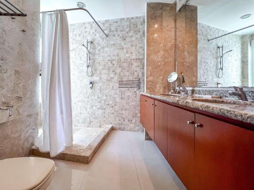 a bathroom with a shower and a sink and a toilet at Isla Condo Puerta al Mar 403 at Sac Bajo in Isla Mujeres