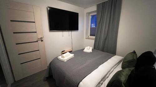 a bedroom with a bed and a flat screen tv at Veløyveien 4b in Sandefjord