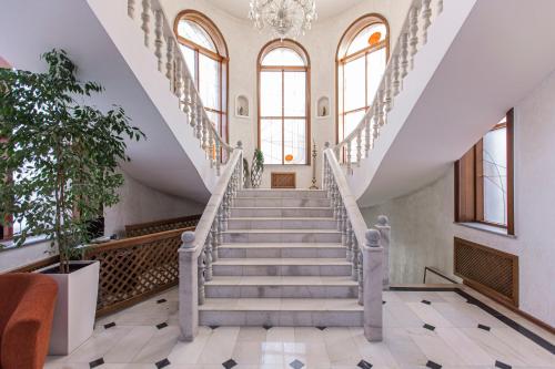 a staircase in a building with a chandelier at Ermensai Wellness Boutique Hotel in Almaty