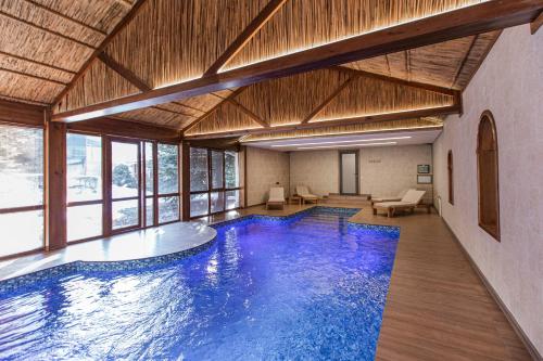 an indoor pool with blue water in a building at Ermensai Wellness Boutique Hotel in Almaty