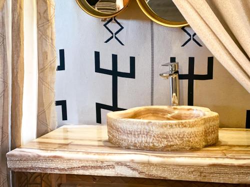 a bathroom with a copper sink on a counter at dreaming desert Luxury Camp in Adrouine