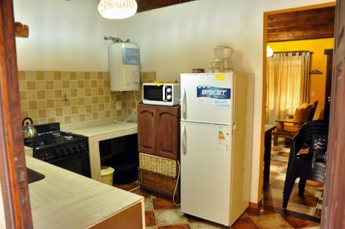 a kitchen with a white refrigerator and a microwave at Cabañas Balboa in Costa del Este