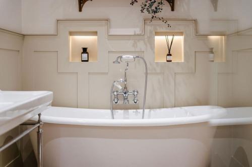 a bathroom with a bath tub with a faucet at The 3 Acres Inn & Restaurant in Huddersfield