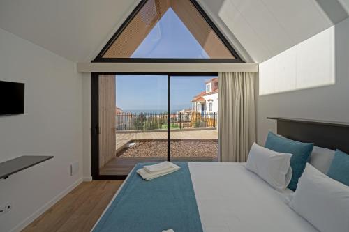 a bedroom with a bed and a large window at Boomerang d'O Século in Ericeira