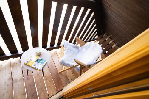 a wooden deck with a table and a chair with a pillow at Marjetina gozdna hiška in Gager