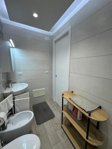 ein Badezimmer mit weißer Toilette und Waschbecken in der Unterkunft Aleila in Bacoli